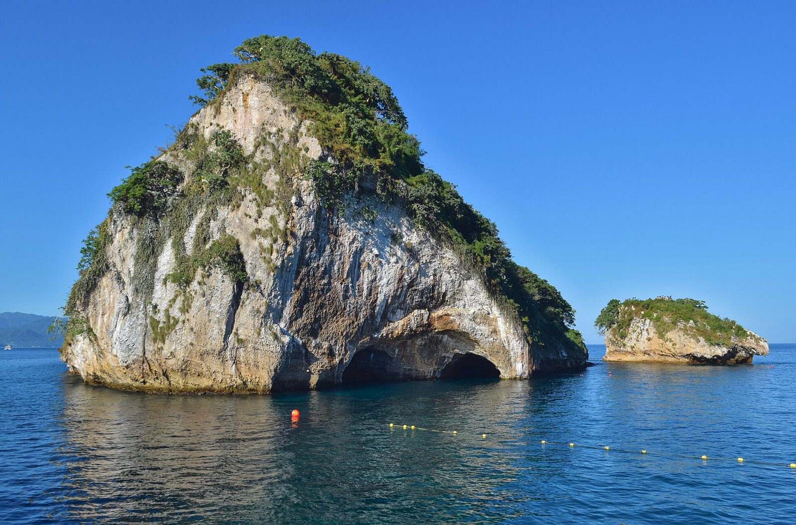 Granite islet with a natural tunnel at its base and a smaller islet beside it at Los Arcos de Mismaloya
