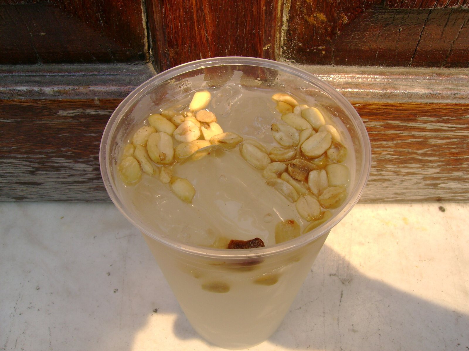 Cup of tuba over ice topped with peanuts, seen from above