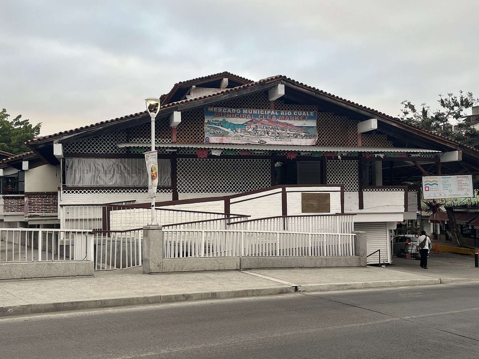 Mercado Municipal Río Cuale building with a tiled roof, white lattice walls and a welcome banner